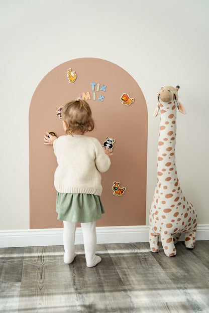 A toddler playing with Tix&Mix magnetic toys on a brown magnetic wall decal.